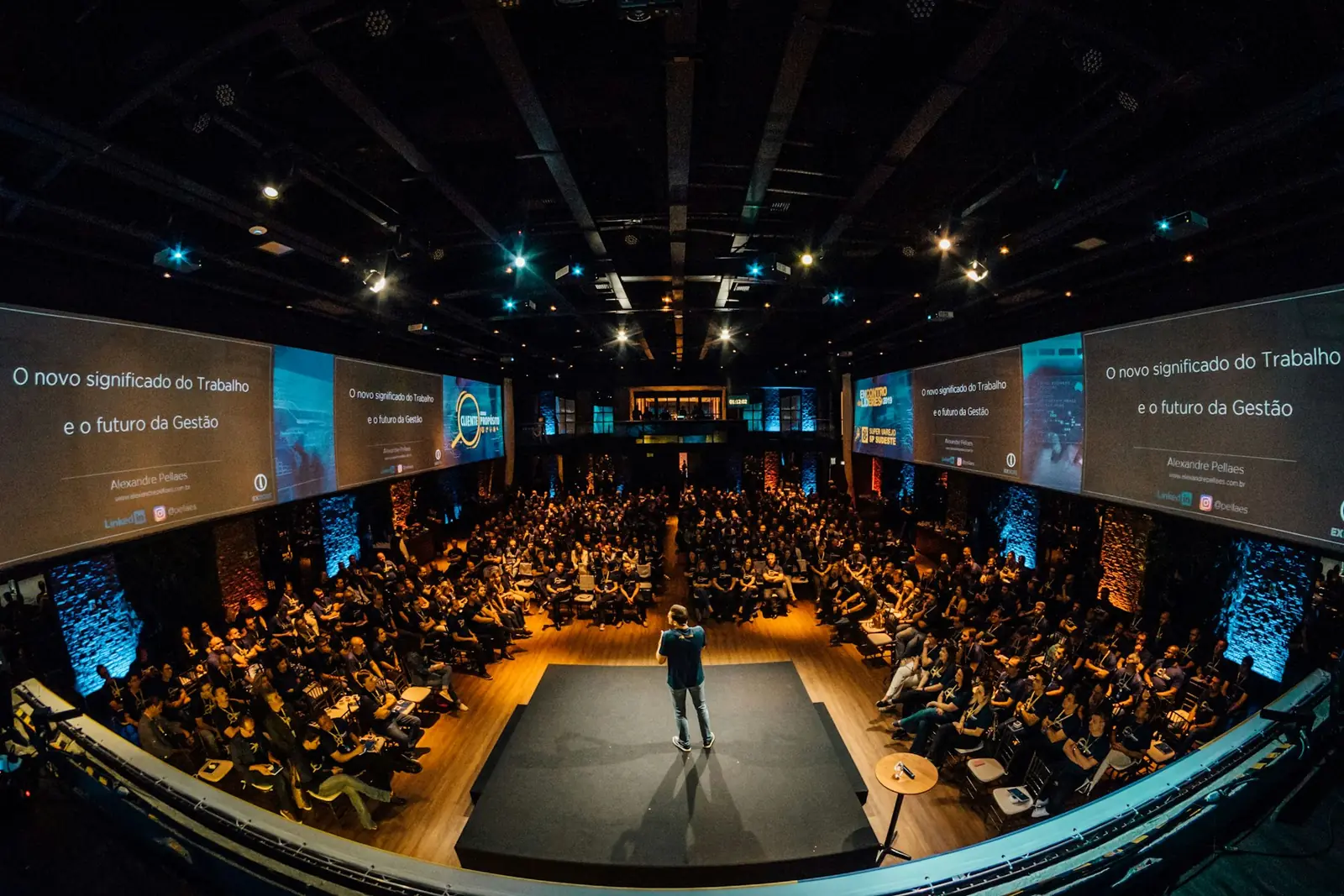 Large auditorium set up for a presentation with stage lighting