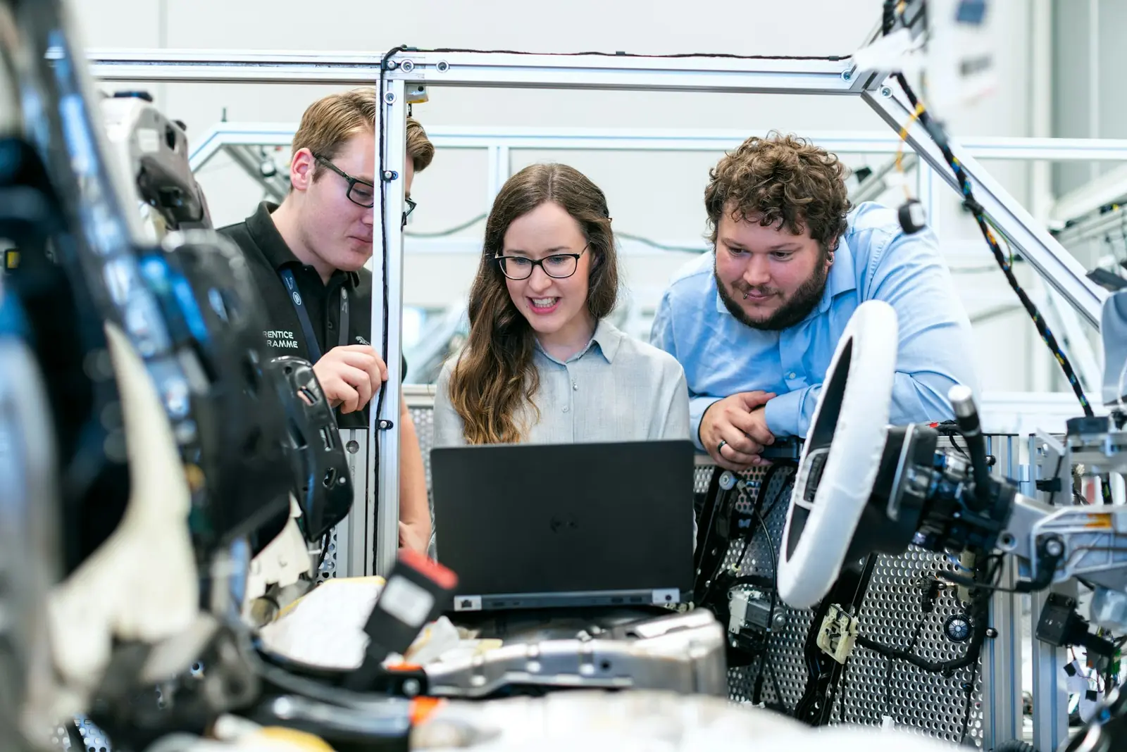 Engineers configuring automated machinery from a laptop on the plant floor