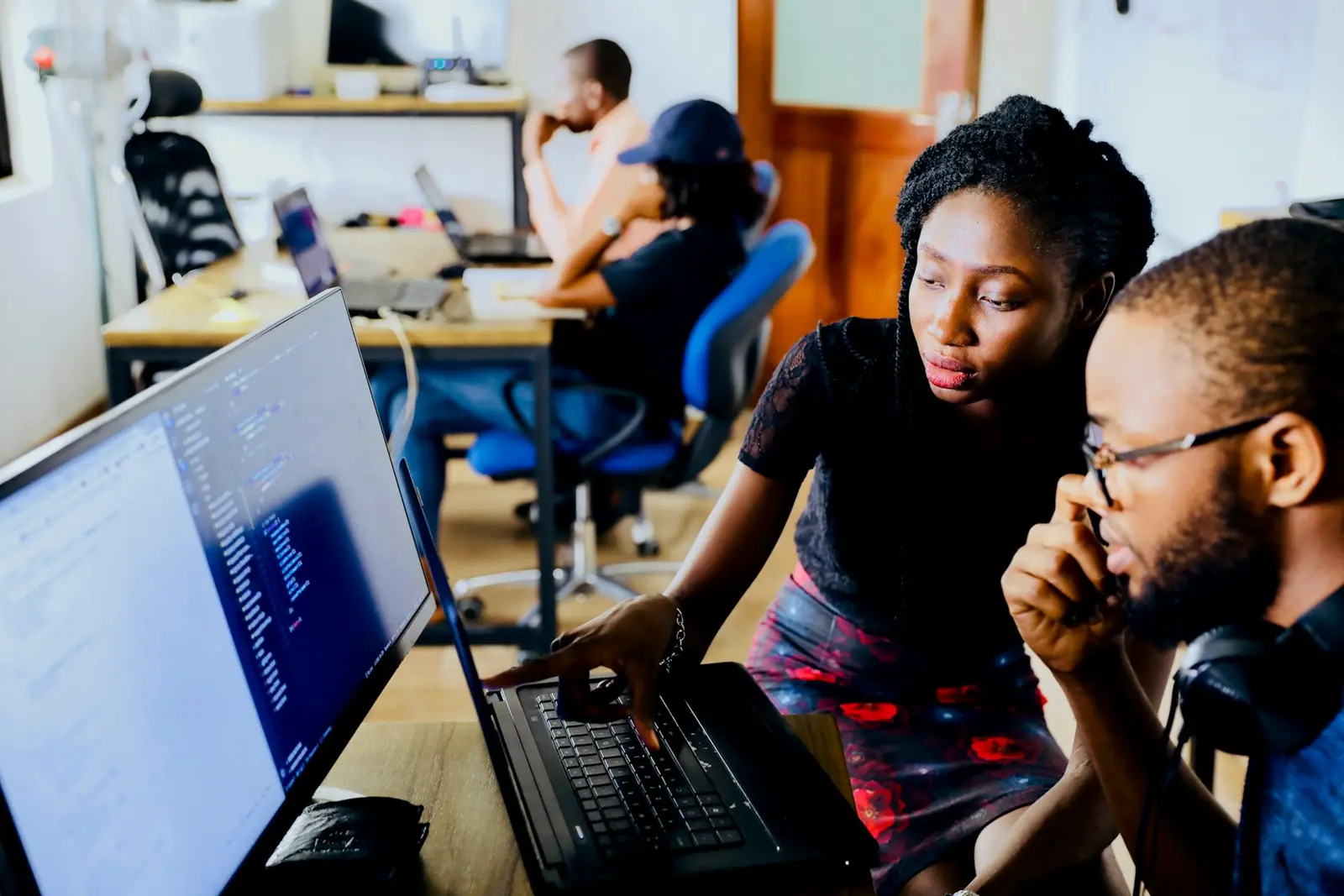 Two developers reviewing code together at a workstation